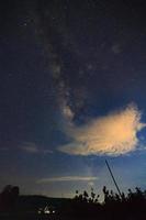 silueta de árbol con nubes y vía láctea. fotografía de larga exposición foto