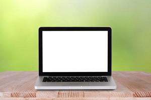 Front view of the laptop is on the work table with bokeh green background photo