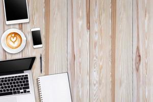 Modern workspace with laptop tablet, smartphone and coffee cup copy space on wood background. Top view. Flat lay style. photo