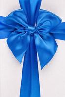 Blue ribbon with bow as gift on white background photo