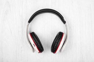 Bluetooth headphones on white wood background photo