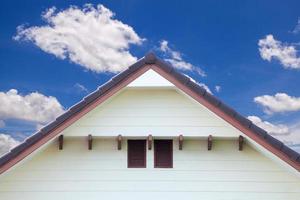 detalle de la pared exterior de la casa y cielo azul con nubes foto