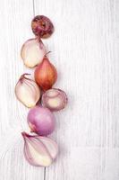 red slice onion bulb on white wood table photo