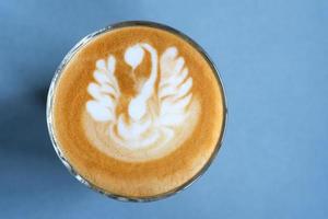 Coffee latte art on blue table background photo