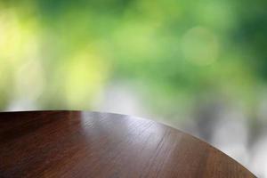 mesa de madera sobre fondo verde bokeh - se puede utilizar para montar o mostrar sus productos foto