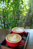 two latte art coffee in red cup photo