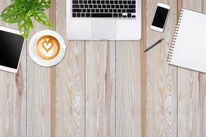 Modern workspace with laptop tablet, smartphone and coffee cup copy space on white wood table background. Top view. Flat lay style. photo