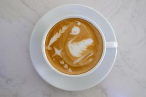 Top view latte art coffee on white table photo