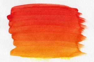 acuarela roja y naranja abstracta sobre fondo blanco. el color salpica en el papel. es un dibujo a mano. foto