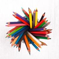 lápices de colores sobre una mesa de madera blanca foto