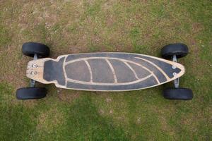 Old wooden skateboard on grass photo