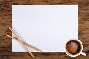 papel en blanco y una taza de café en madera foto