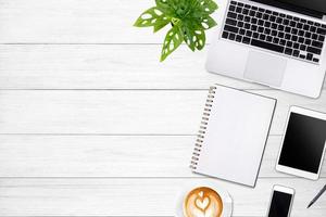 Modern workspace with laptop tablet, smartphone and coffee cup copy space on white wood table background. Top view. Flat lay style. photo