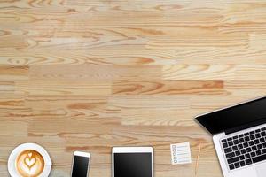 Modern workspace with laptop tablet, smartphone and coffee cup copy space on wood background. Top view. Flat lay style. photo