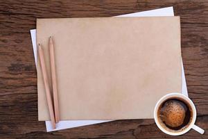 papel en blanco con lápiz y una taza de café en madera foto