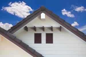 detalle de la pared exterior de la casa y cielo azul con nubes foto