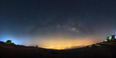 panorama de la galaxia de la vía láctea y la luz de la ciudad en phutabberk phetchabun en tailandia. fotografía de larga exposición. con grano foto