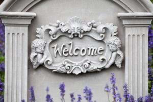 Welcome sign on stone background with lavender flower photo