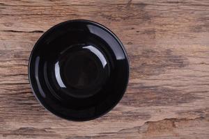 Empty black bowl on wood photo