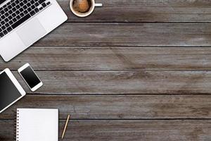 Modern workspace with laptop tablet, smartphone and coffee cup copy space on wood background. Top view. Flat lay style. photo