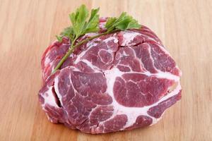 Fresh crude pork neck meat steak on wood background photo