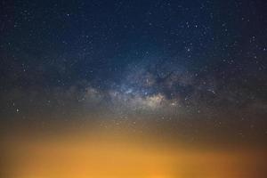 Milky way galaxy with stars and city light, Long exposure photograph, with grain. photo