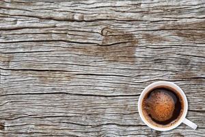 una taza de café sobre fondo de textura de madera foto