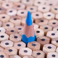 One sharpened blue pencil among many ones photo