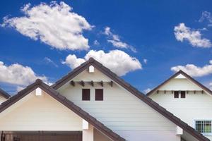 detalle de la pared exterior de la casa y cielo azul con nubes foto