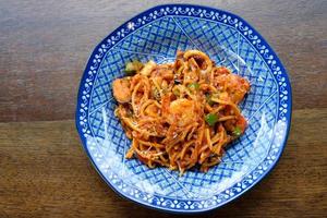 spaghetti seafood tomato sauce on wood table photo