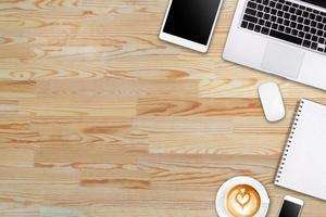 Modern workspace with laptop tablet, smartphone and coffee cup copy space on wood background. Top view. Flat lay style. photo