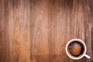 una taza de café sobre fondo de textura de madera foto