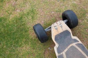 Old wooden skateboard on grass photo