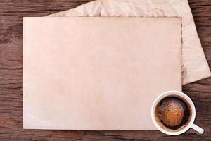 Old blank paper and a cup of coffee on wooden photo