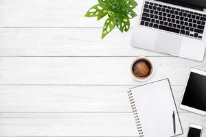 Modern workspace with laptop tablet, smartphone and coffee cup copy space on white wood table background. Top view. Flat lay style. photo