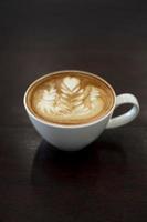 Close-up latte art coffee on wood table photo