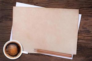 papel en blanco con lápiz y una taza de café en madera foto