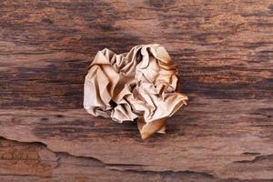 crumpled paper ball on wood photo