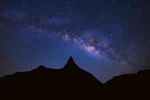 Starry night sky with high moutain and milky way galaxy with stars and space dust in the universe photo