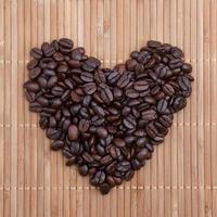 Coffee beans in shape of heart on wood photo
