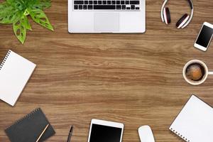 Modern workspace with laptop tablet, smartphone and coffee cup copy space on color background. Top view. Flat lay style. photo