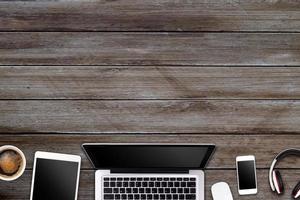 Modern workspace with laptop tablet, smartphone and coffee cup copy space on wood background. Top view. Flat lay style. photo