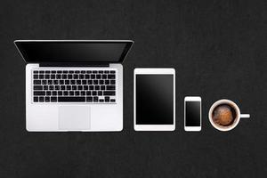 Laptop tablet smartphone  and coffee on rock table background with text space and copy space photo