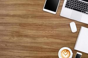 Modern workspace with laptop tablet, smartphone and coffee cup copy space on wood background. Top view. Flat lay style. photo