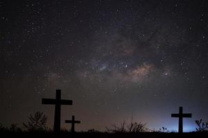 Silhouette of cross over milky way background,Long exposure photograph photo