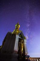 vía láctea en el nombre de la imagen de buda de oro de pie es wat sra song pee nong en phitsanulok, tailandia, fotografía de larga exposición foto