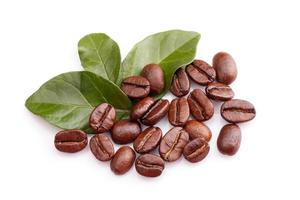 granos de café y hojas sobre fondo blanco foto