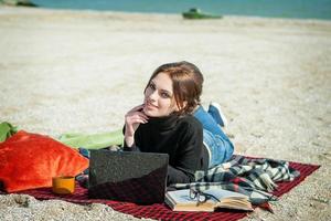 mujer joven disfrutando de su trabajo en la playa foto