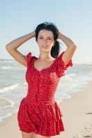 Young girl in red dress on the sea photo