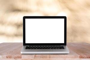 Front view of the laptop is on the work table with bokeh green background photo